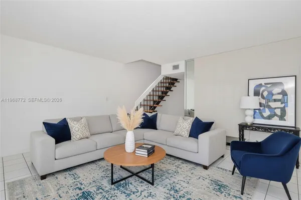 a living room with furniture and a potted plant