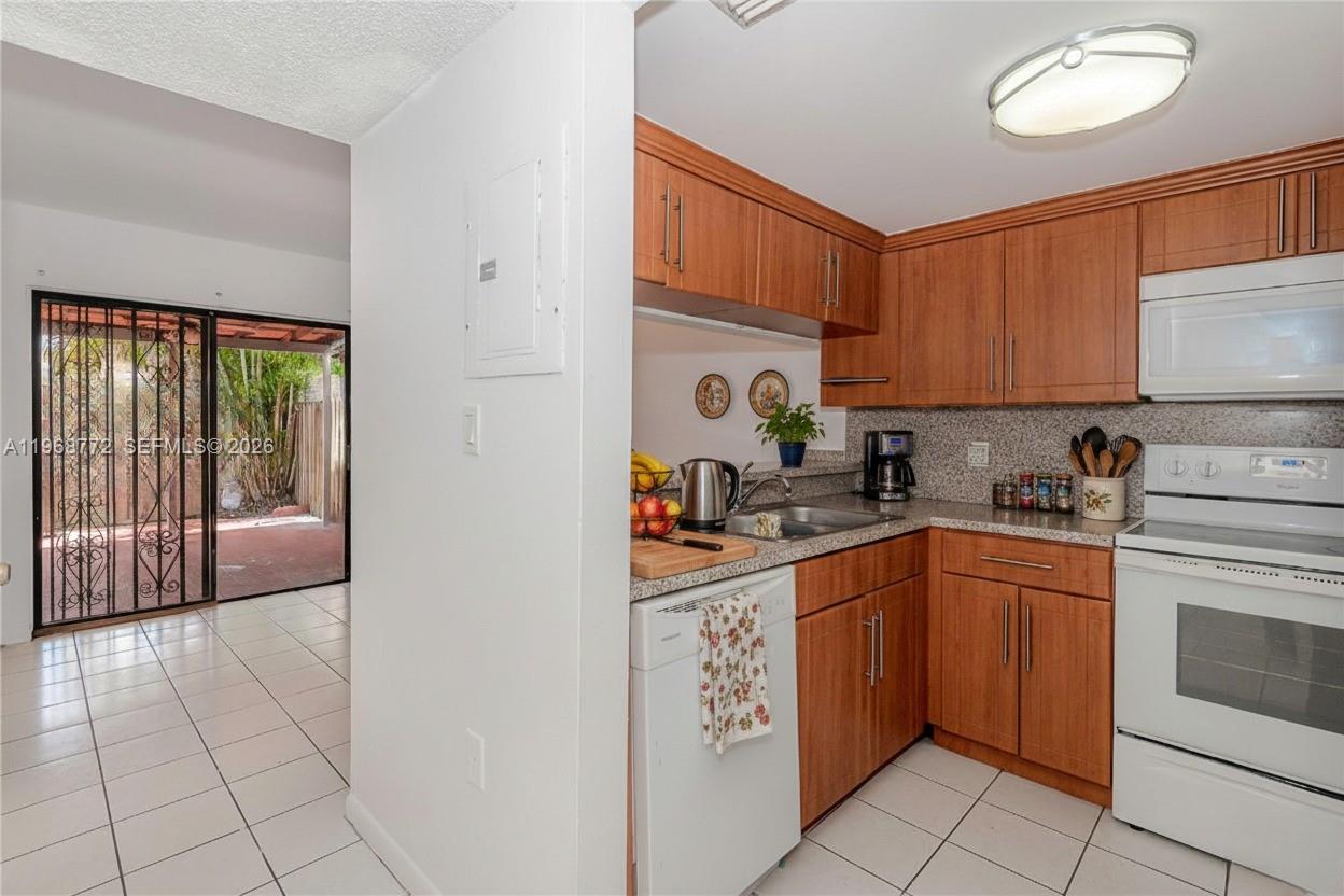 1082 West 79th Street, Unit 25 Hialeah, FL 33014 - Photo 7 of 16 a kitchen with stainless steel appliances granite countertop a stove a sink and a refrigerator