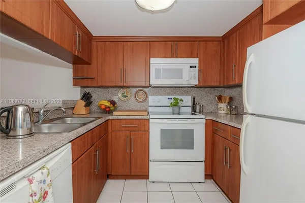 a kitchen with stainless steel appliances granite countertop a sink stove refrigerator and cabinets