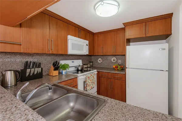 a kitchen with stainless steel appliances granite countertop a sink refrigerator stove and microwave