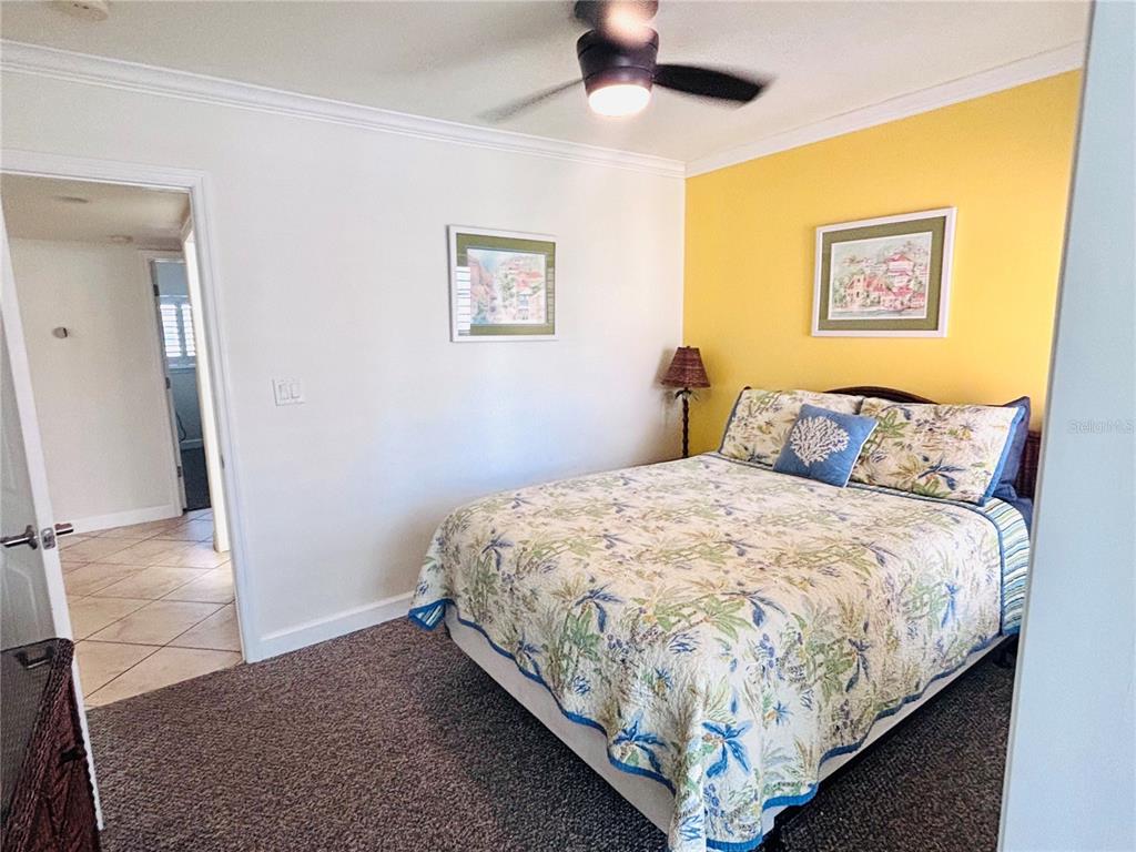 19417 Gulf Boulevard, Unit B209 Indian Rocks Beach, FL 33785 - Photo 15 of 24 a bed sitting in a bedroom next to a bathroom