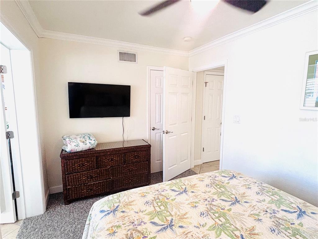 19417 Gulf Boulevard, Unit B209 Indian Rocks Beach, FL 33785 - Photo 16 of 24 a bedroom with a bed and a flat screen tv