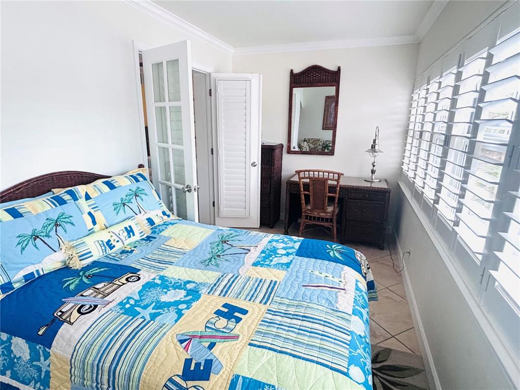 19417 Gulf Boulevard, Unit B209 Indian Rocks Beach, FL 33785 - Photo 17 of 24 a bedroom with a bed and dresser with mirror