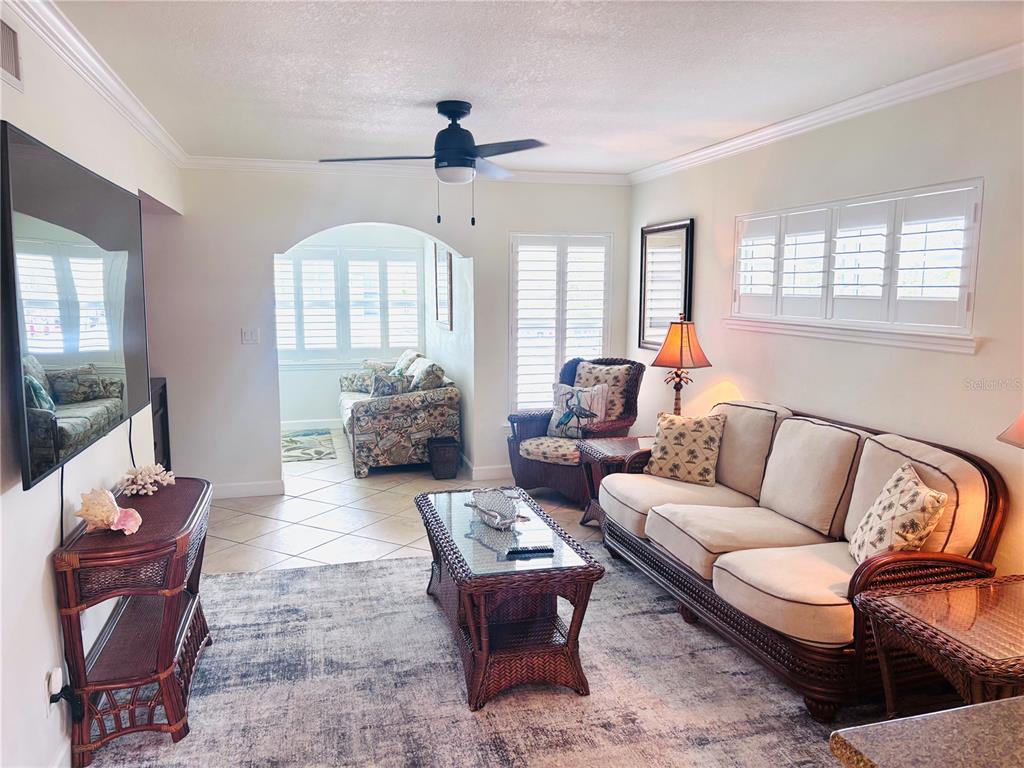 19417 Gulf Boulevard, Unit B209 Indian Rocks Beach, FL 33785 - Photo 4 of 24 a living room with furniture ceiling fan and a window