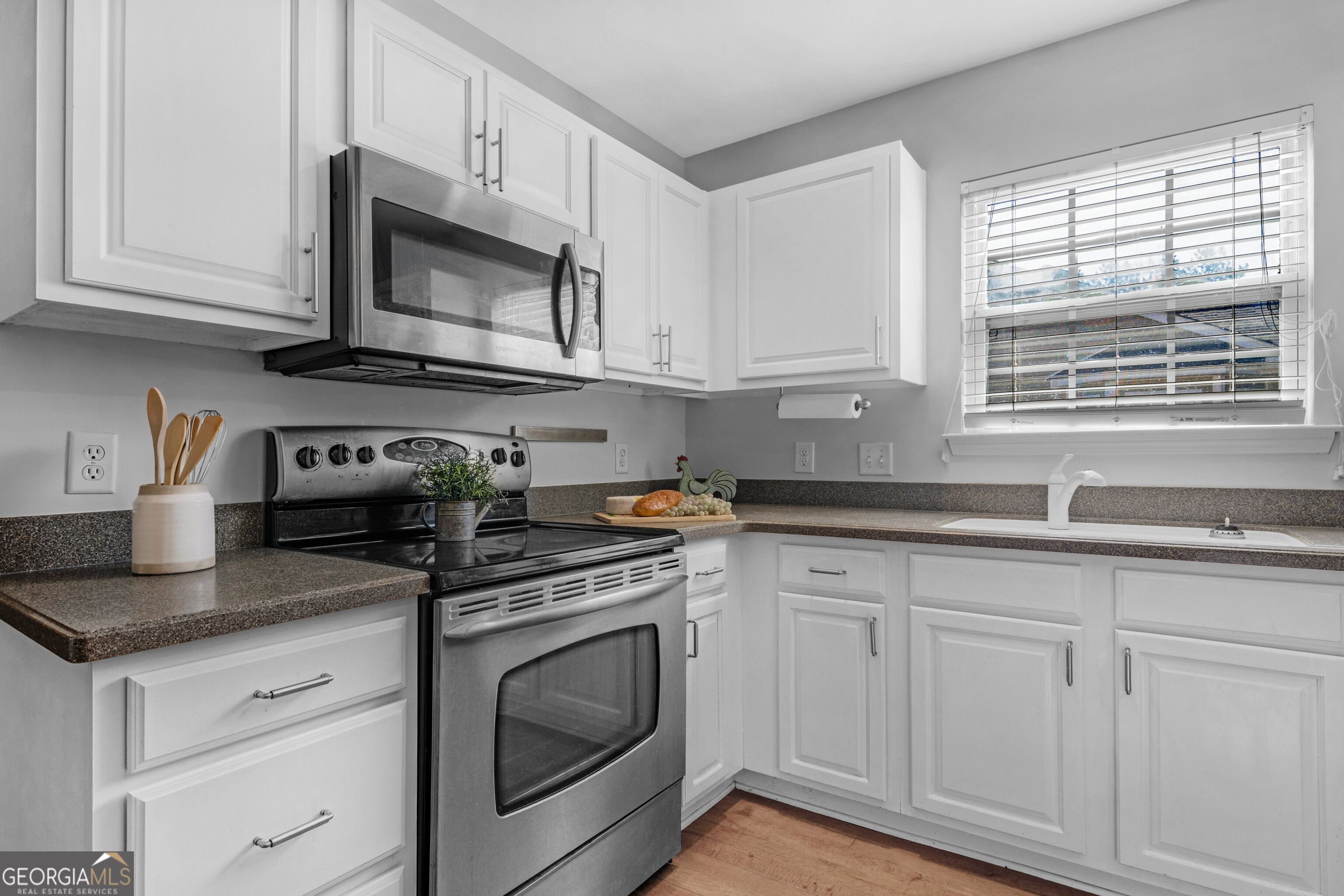 172 Sonata Circle Pooler, GA 31322 - Photo 8 of 48 a kitchen with granite countertop white cabinets stainless steel appliances and a sink