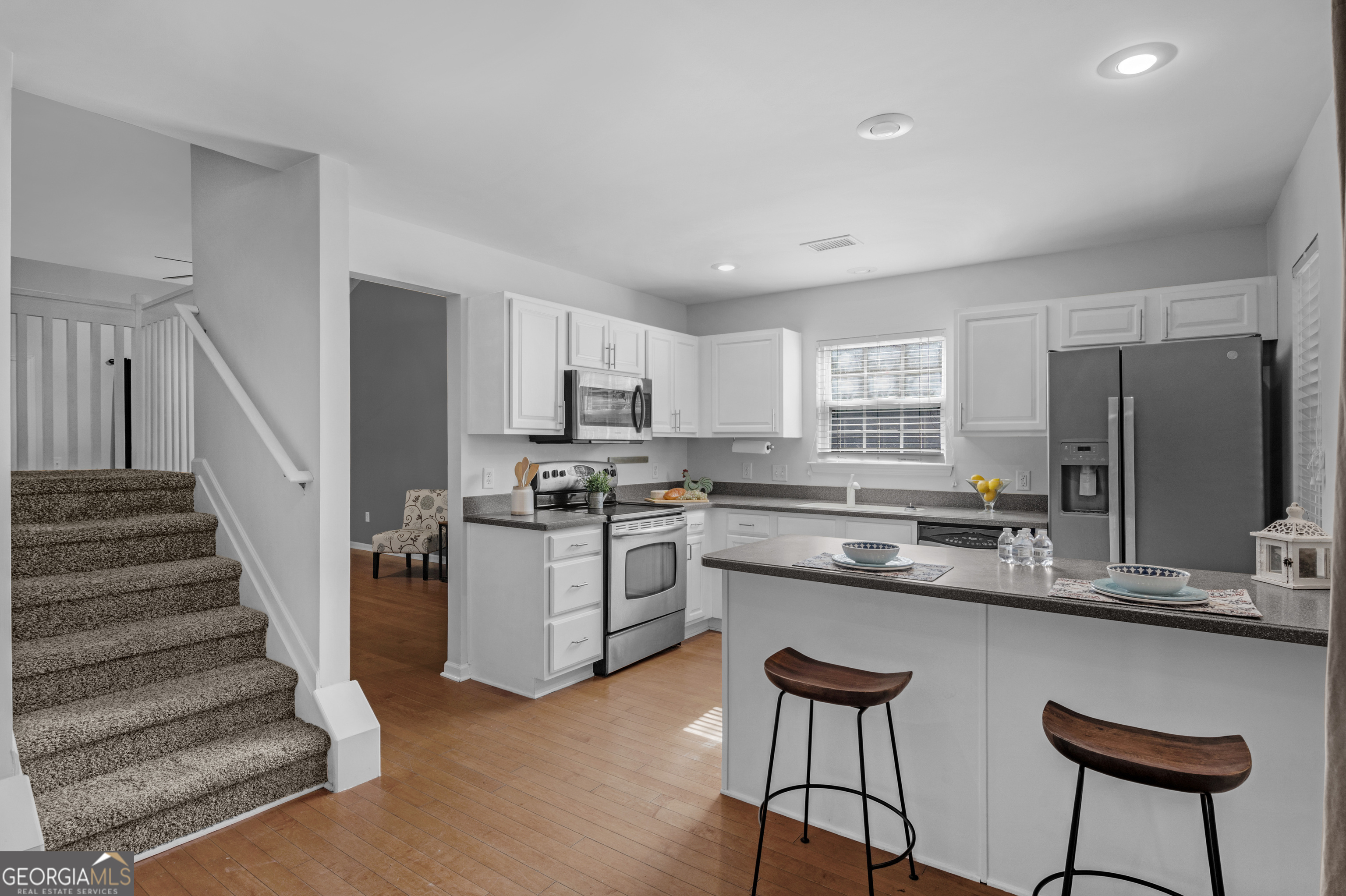 172 Sonata Circle Pooler, GA 31322 - Photo 10 of 48 a kitchen with stainless steel appliances kitchen island a refrigerator and wooden cabinets