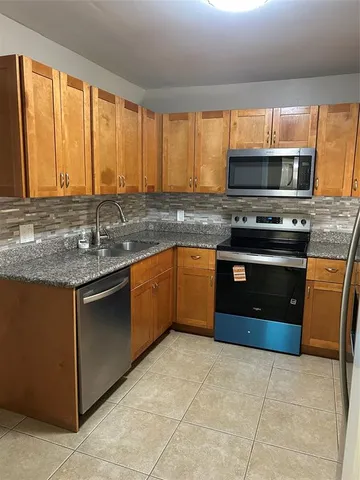 a kitchen with stainless steel appliances granite countertop a refrigerator and a sink