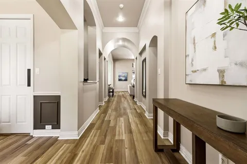a view of a hallway with entryway wooden floor and front door