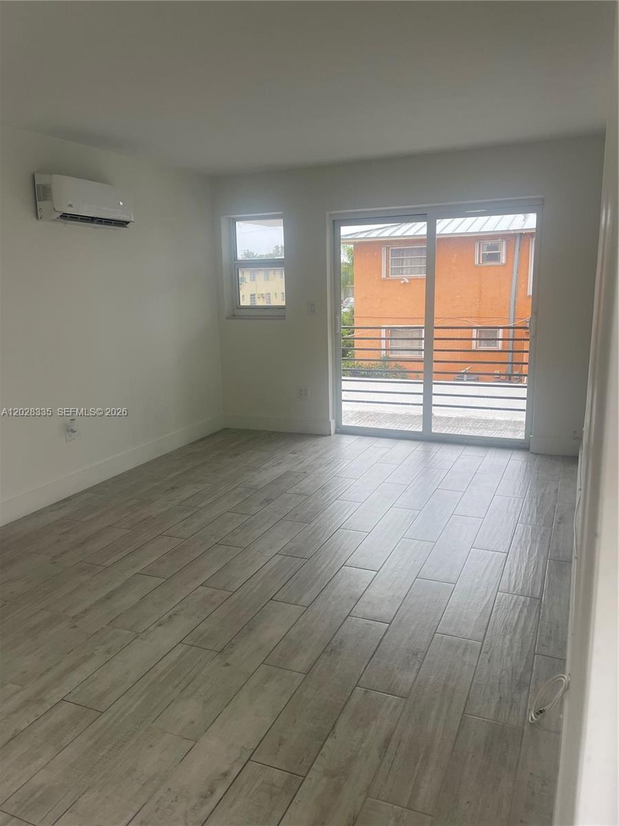 2008 Southwest 3rd Street, Unit 4 Miami, FL 33135 - Photo 4 of 15 an empty room with wooden floor and windows
