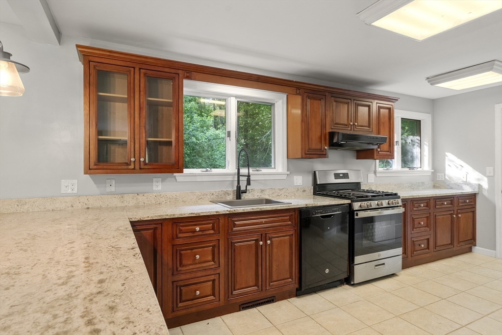 731 R Grove Street Norwell, MA 02061 - Photo 8 of 42 a kitchen with stainless steel appliances granite countertop a stove a sink and a microwave