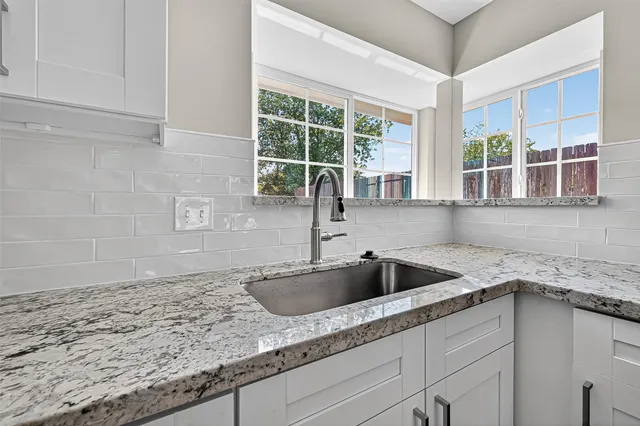 a kitchen with granite countertop a sink and a window