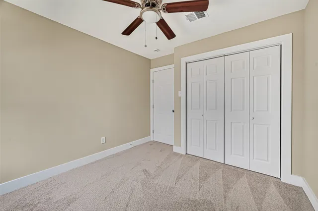an empty room with chandelier fan