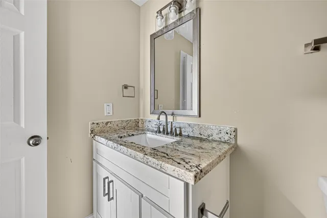 a bathroom with a granite countertop sink and a mirror