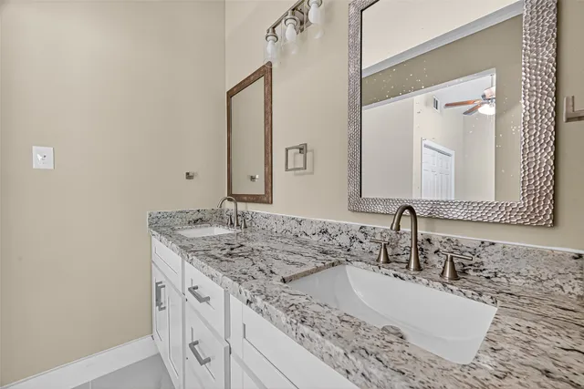 a bathroom with a granite countertop sink and a mirror