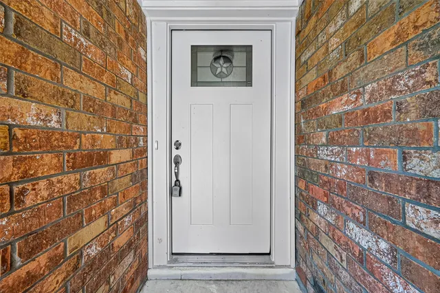 a view of a door and brick walls