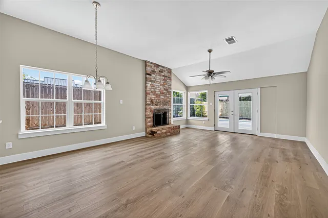 a view of empty room with wooden floor and fireplace