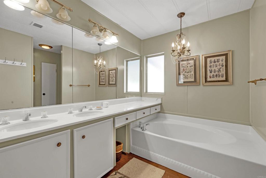 1010 Palm Canyon Drive, Unit 151 Borrego Springs, CA 92004 - Photo 23 of 31 a spacious bathroom with a granite countertop sink a mirror a bathtub and shower