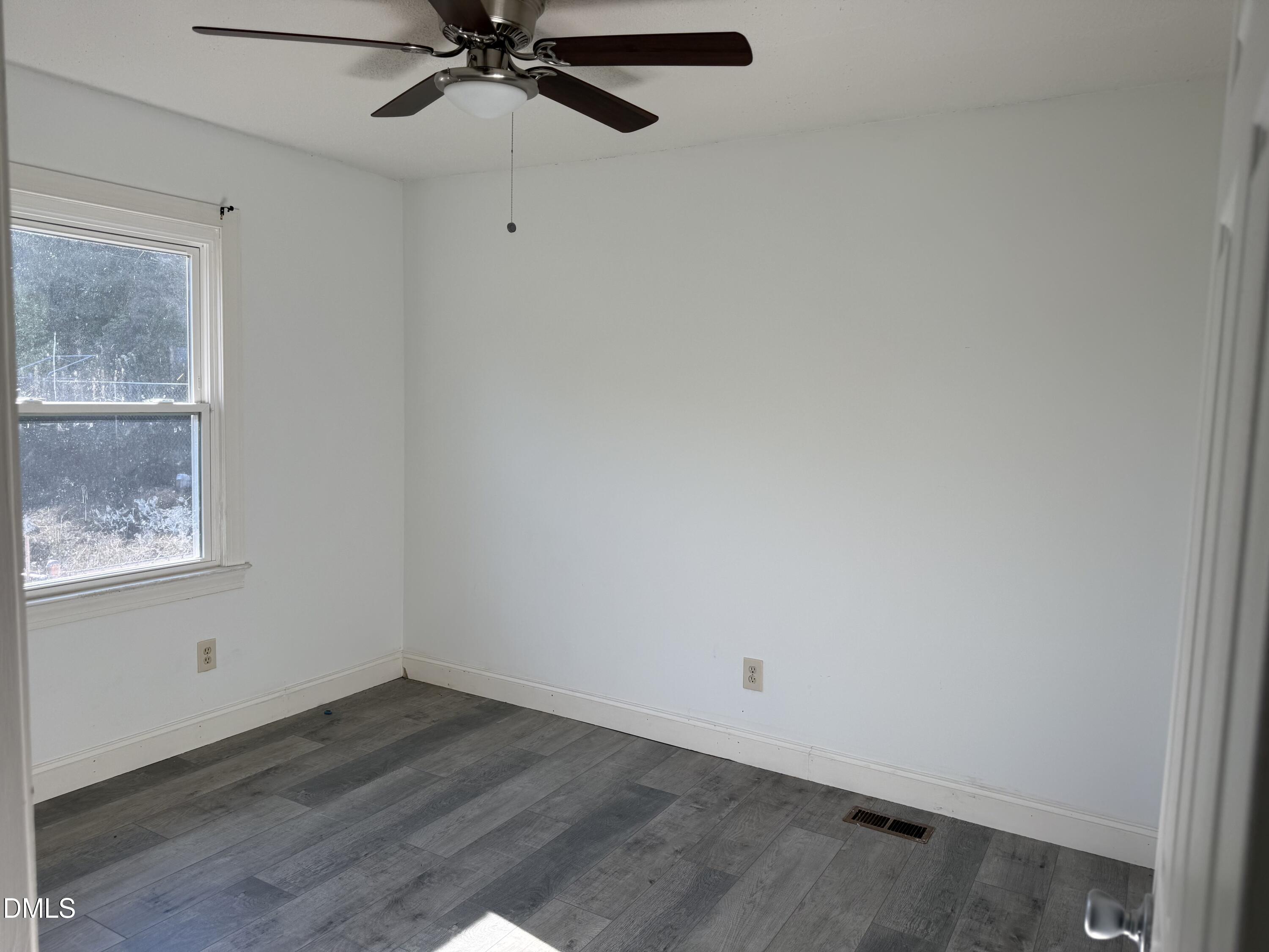 5509 Sandy Run Knightdale, NC 27545 - Photo 18 of 21 a view of an empty room with wooden floor and a window