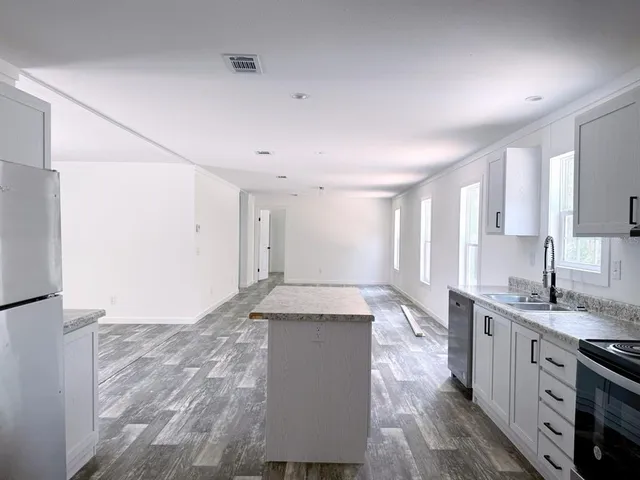 a spacious bathroom with a granite countertop sink a toilet a mirror and vanity