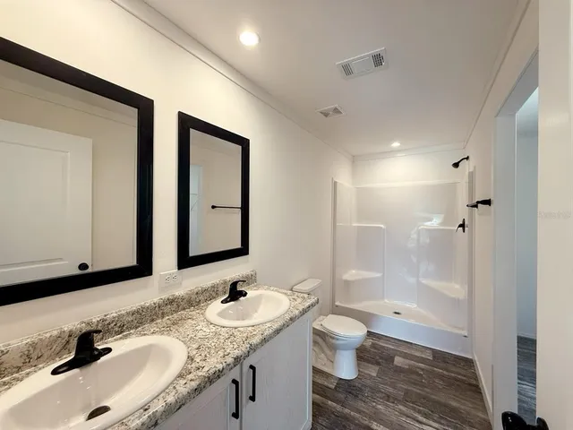 a bathroom with a granite countertop sink toilet and shower