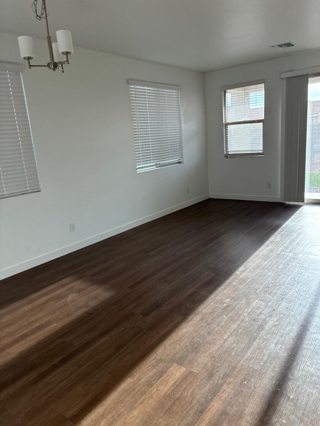 5630 South Daisy Patch Place Phoenix, AZ 85040 - Photo 3 of 14 an empty room with wooden floor and windows