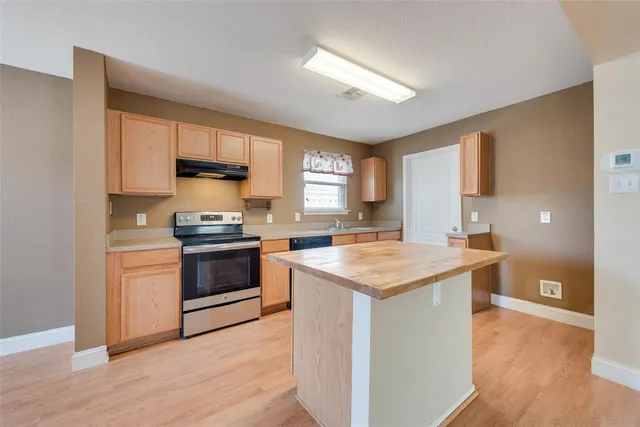 a kitchen with a stove a sink and a refrigerator