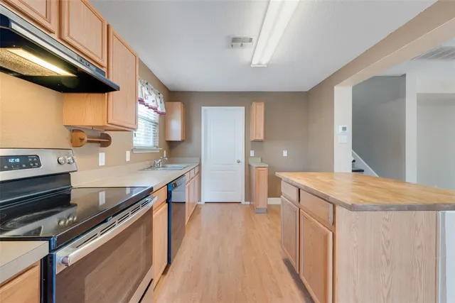 a kitchen with stainless steel appliances granite countertop a sink and a stove