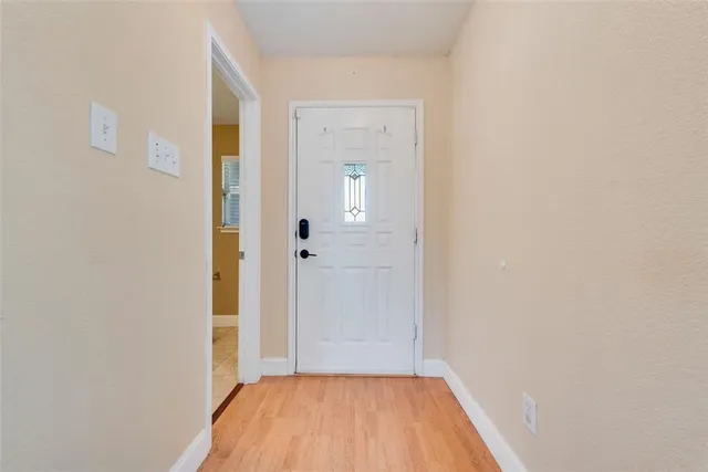 a view of a hallway with wooden floor and a bathroom