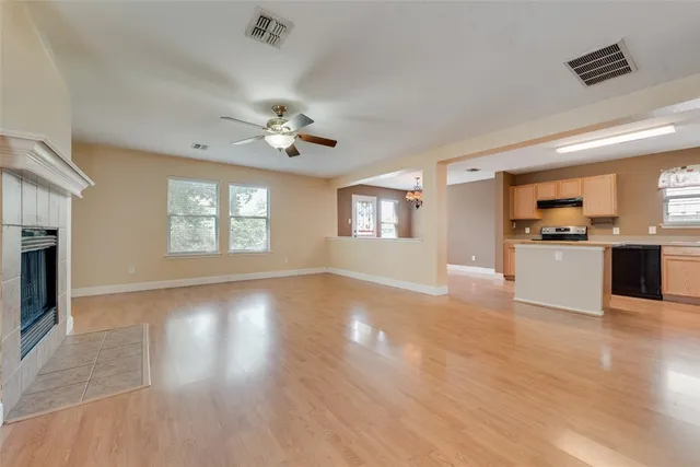 a view of an empty room with a kitchen and a window