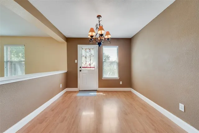 a view of a livingroom with wooden floor and chandelier