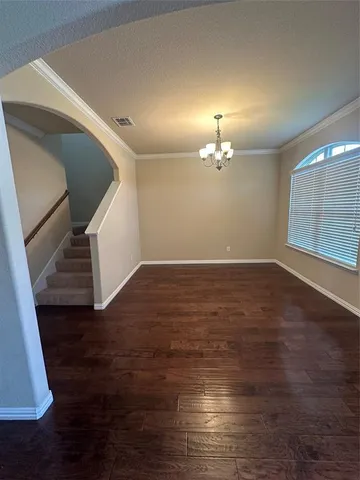 a view of an empty room with wooden floor and a fireplace