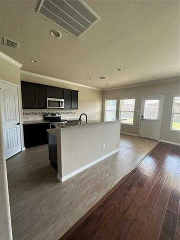 a view of kitchen with wooden floor and electronic appliances