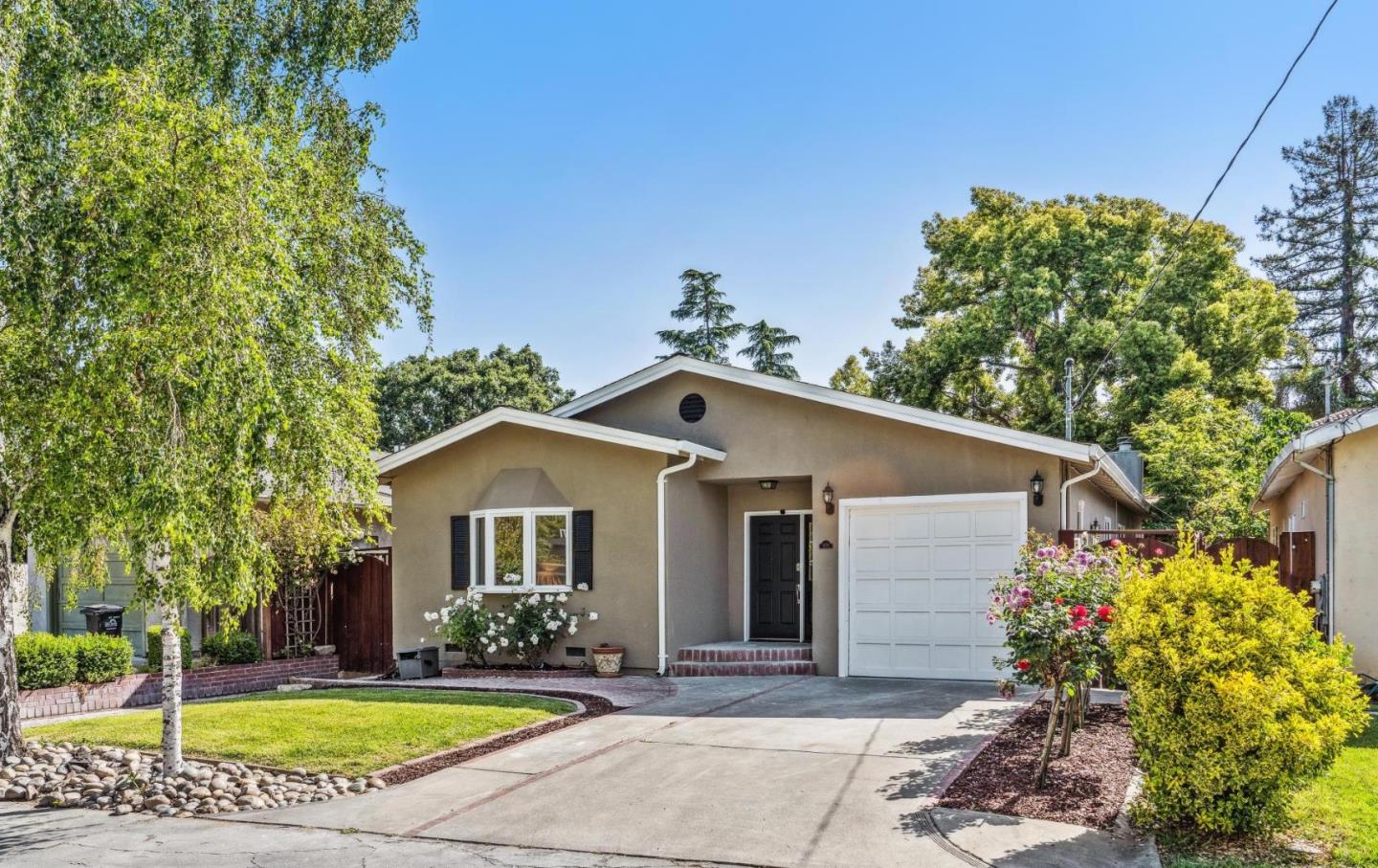 a view of a house with a yard and potted plants