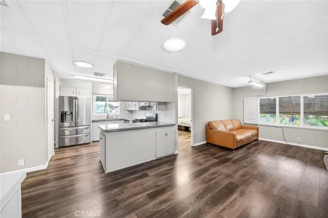 a kitchen with stainless steel appliances granite countertop a stove a sink dishwasher and a refrigerator with wooden floor