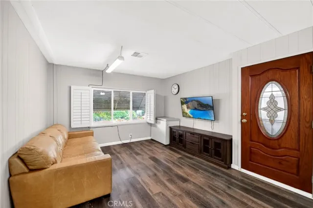 a living room with furniture a flat screen tv and a floor to ceiling window