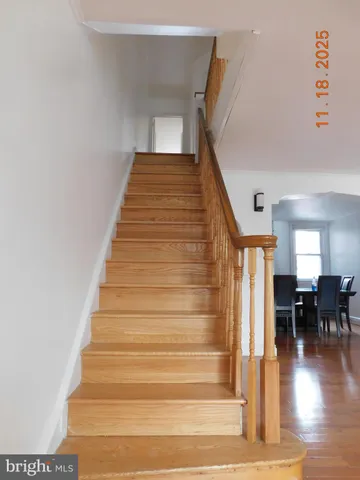 a view of entryway and hall with wooden floor