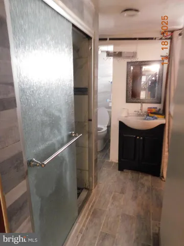 a bathroom with a sink and mirror with toilet