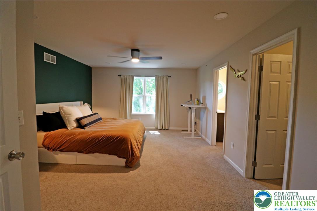 4502 Benjamin Court Emmaus, PA 18049 - Photo 25 of 53 A restful primary bedroom retreat features plush carpeting, a large window, and an en-suite bathroom.