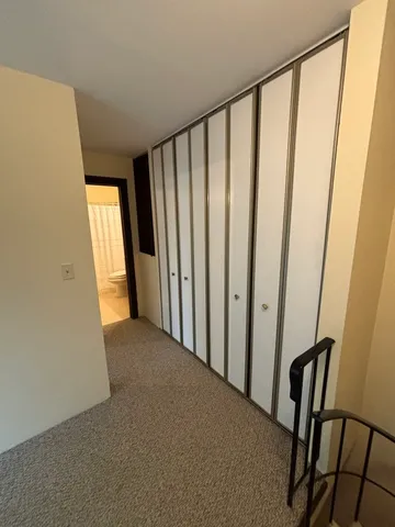 a view of a hallway with wooden floor and staircase