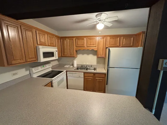 a kitchen with granite countertop a refrigerator stove top oven and sink