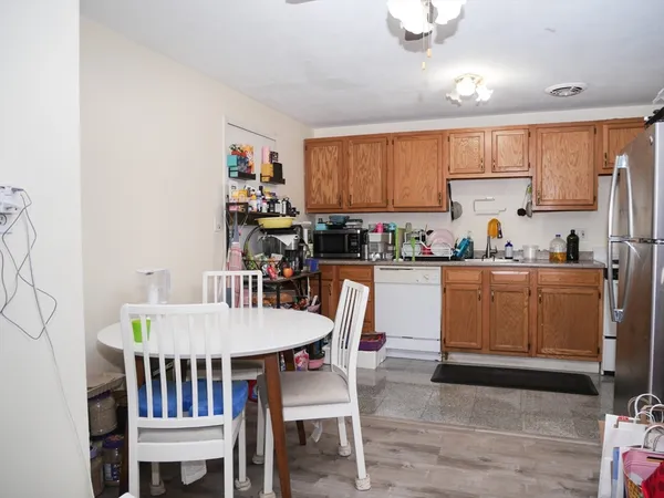 a kitchen with a dining table chairs and white cabinets