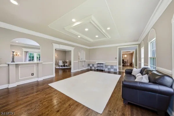 a living room with furniture a flat screen tv and kitchen view