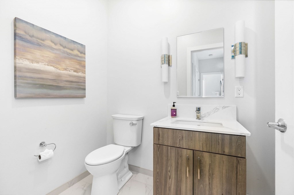 10 Shipyard Drive, Unit 312 Hingham, MA 02043 - Photo 22 of 35 a bathroom with a toilet sink and mirror