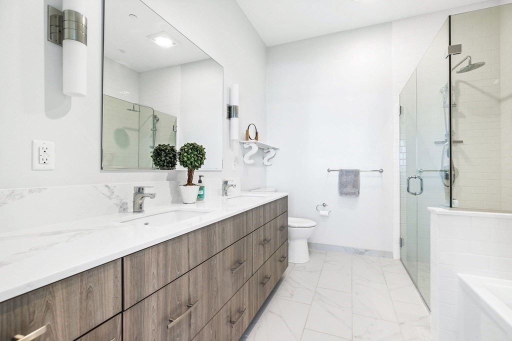 10 Shipyard Drive, Unit 312 Hingham, MA 02043 - Photo 26 of 35 a bathroom with a double vanity sink toilet mirror and shower