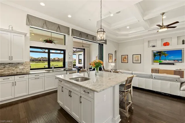 a large white kitchen with a stove a sink dishwasher and a refrigerator with wooden floor
