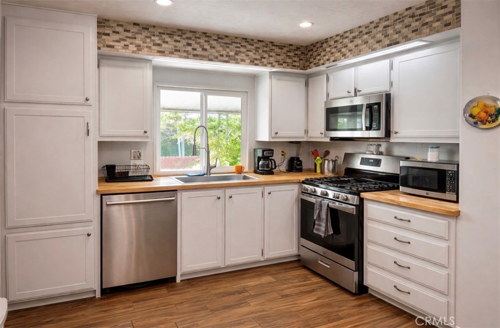 13870 Rodeo Drive Victorville, CA 92395 - Photo 8 of 22 a kitchen with stainless steel appliances granite countertop a stove a sink and a microwave