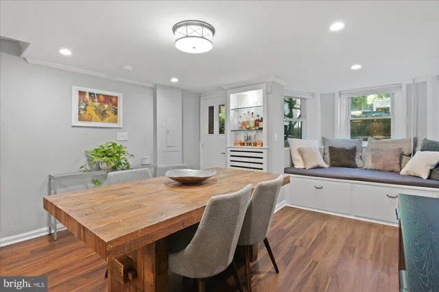 a living room with furniture a potted plant and open kitchen view