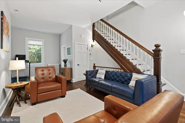 a living room with furniture a flat screen tv and a window