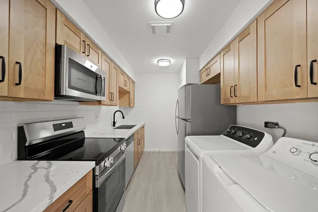 a kitchen with stainless steel appliances a stove microwave and refrigerator