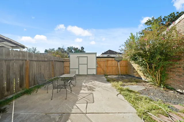 a backyard of a house with table and chairs